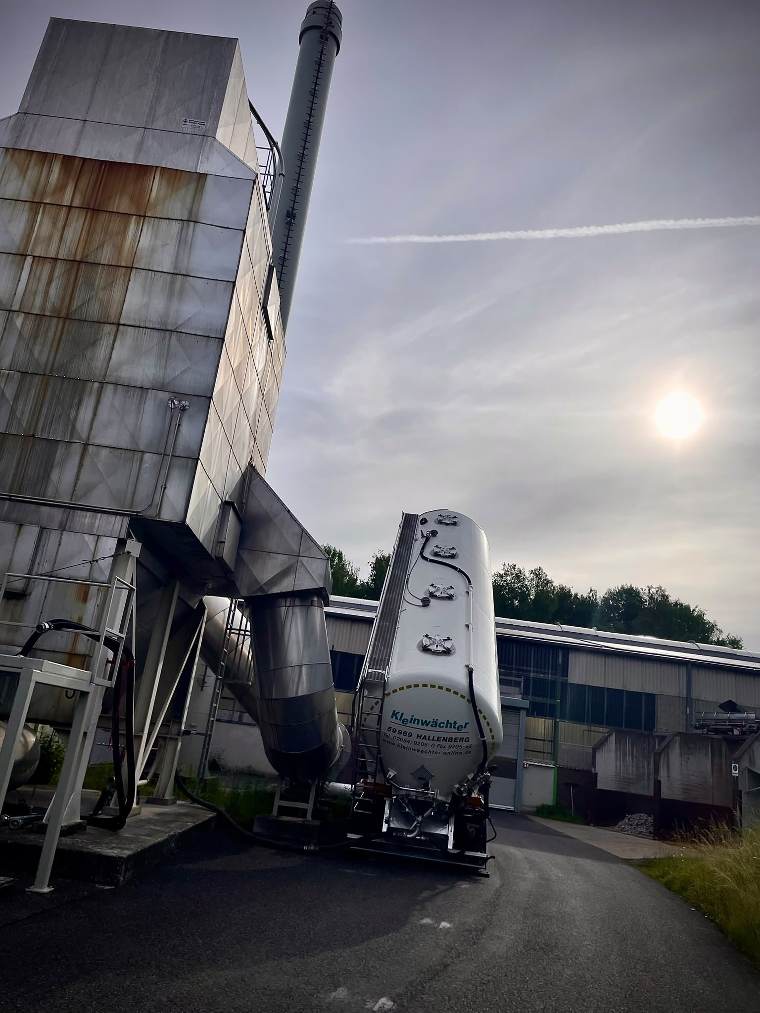 Kleinwächter Kippsilo an einer Industrieanlage im Gegenlicht