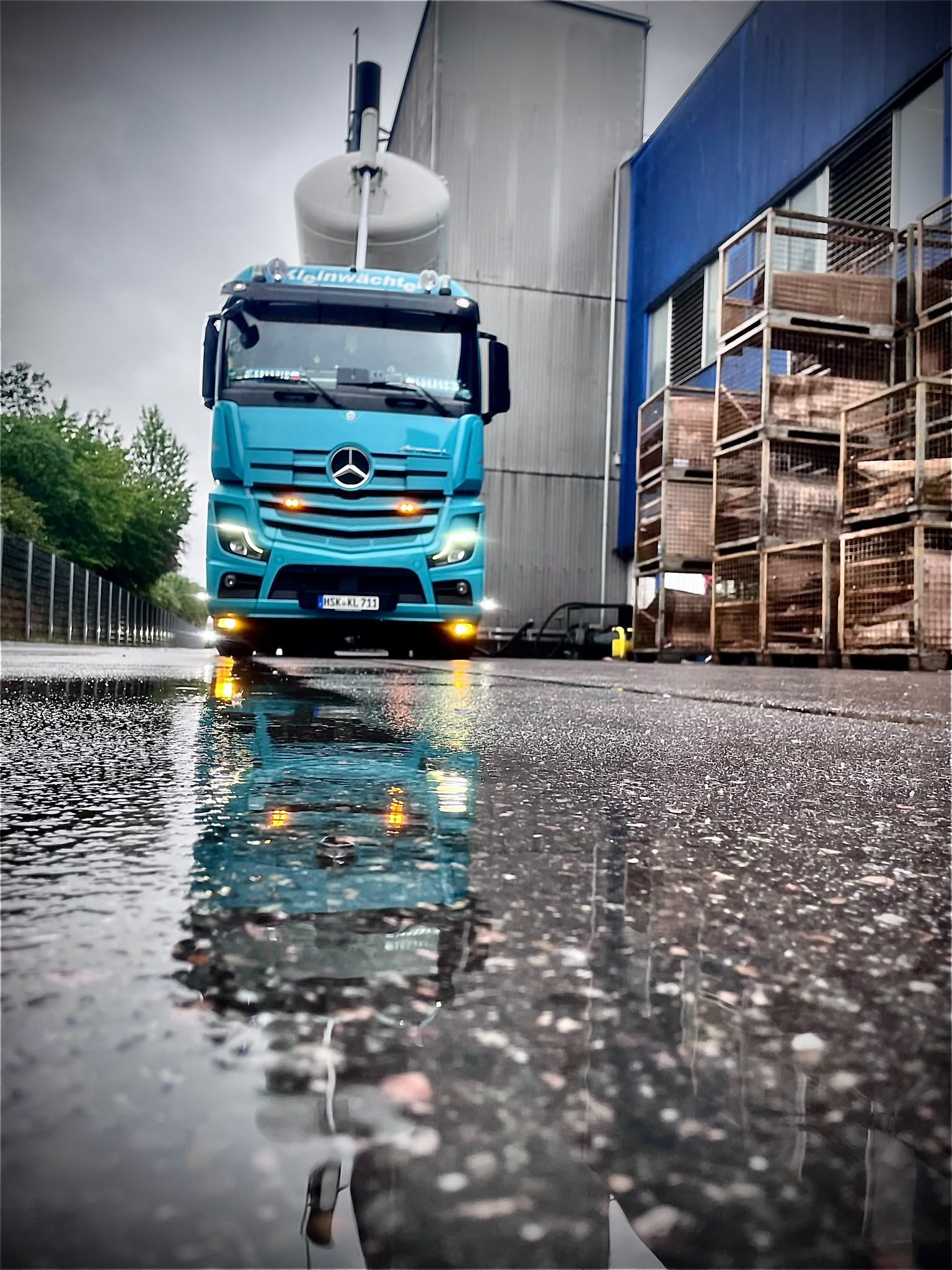 Kleinwächter Lkw mit Spiegelung auf nasser Fahrbahn
